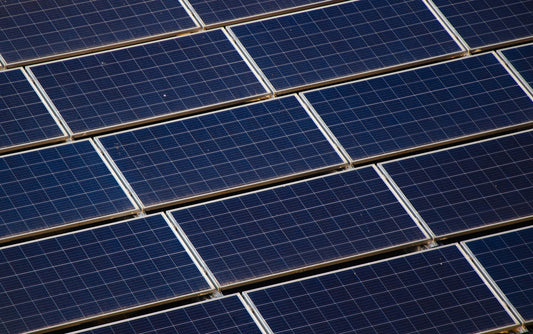 a large amount of solar panels on the roof of a building