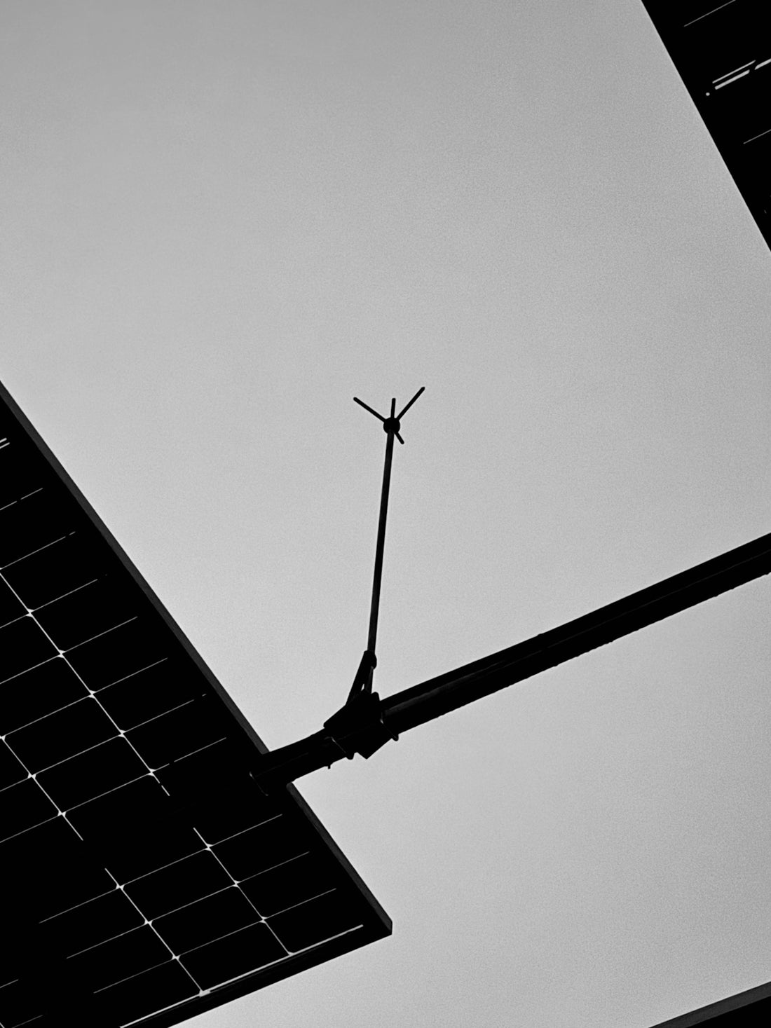A black and white photo of a street light and a solar panel